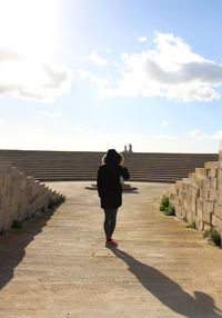 Rear view of woman against cloudy sky