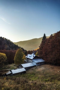 Houses by trees and mountains against sky