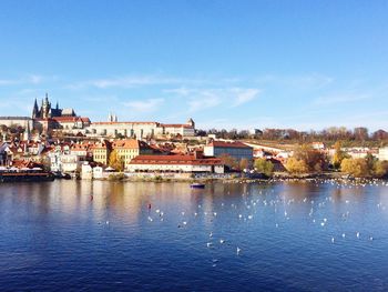 Residential district by river against sky