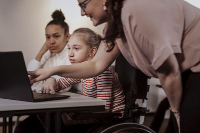 Women with girl using laptop