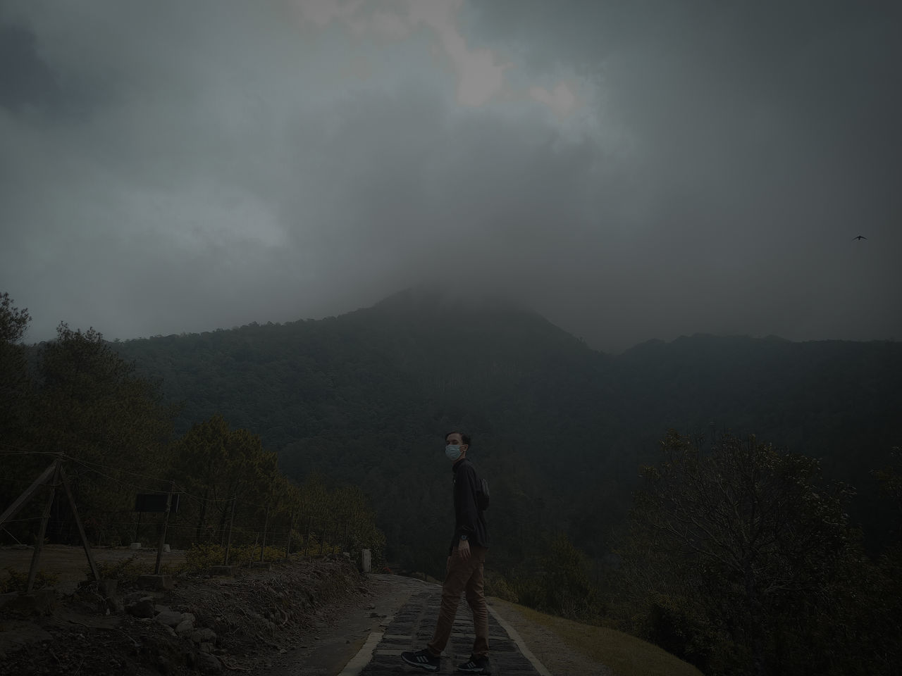 MAN STANDING ON MOUNTAIN AGAINST SKY DURING SUNRISE