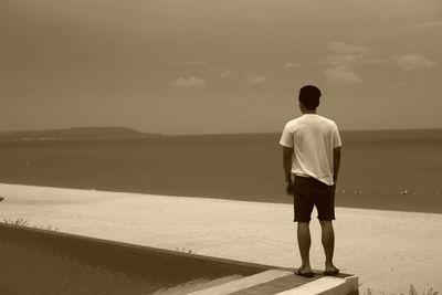 Rear view of man standing on beach