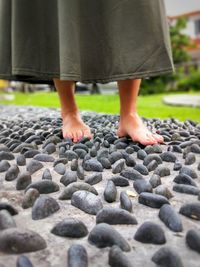 Low section of woman standing on pebbles