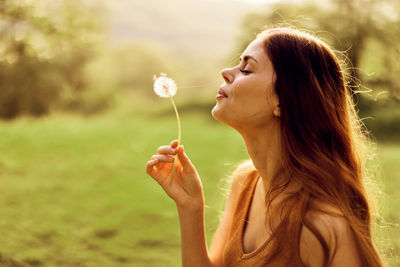 Young woman blowing bubbles at beach