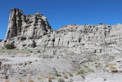 Low angle view of rocks against clear sky