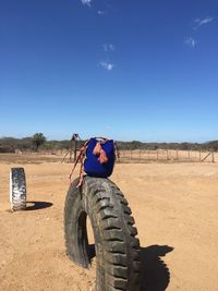 Tire on field against clear sky