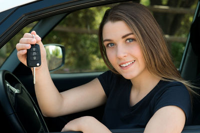 Portrait of a smiling young woman sitting in car