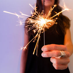 Midsection of woman holding sparkler