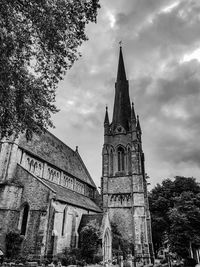 Low angle view of bell tower against cloudy sky