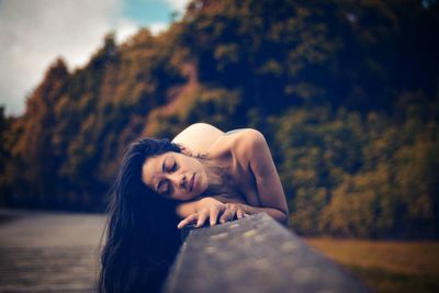 Portrait of beautiful woman against trees