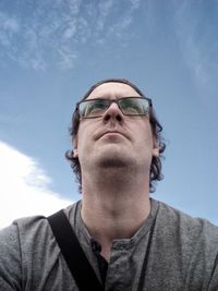 Low angle portrait of man against sky