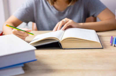 Midsection of woman reading book