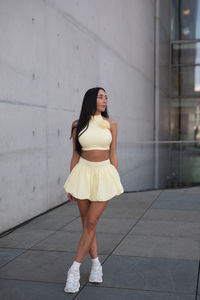 Young woman standing against wall