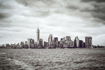 View of cityscape against cloudy sky