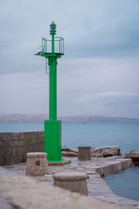 Lighthouse by sea against sky