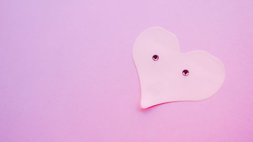 Close-up of heart shape over pink background