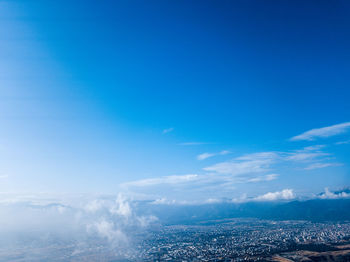 Aerial view of city by sea against sky