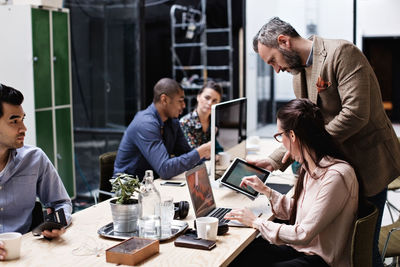 Group of people using mobile phone at table