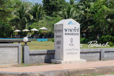 Information sign by palm trees in park