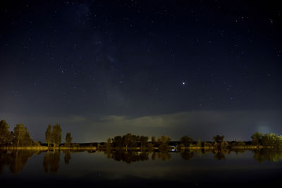 Scenic view of lake against sky at night