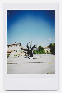 Statue on glass window against clear blue sky