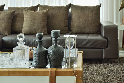 Hourglass and containers on table in living room at home