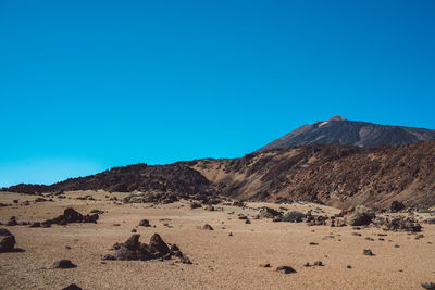 Scenic view of desert against clear blue sky