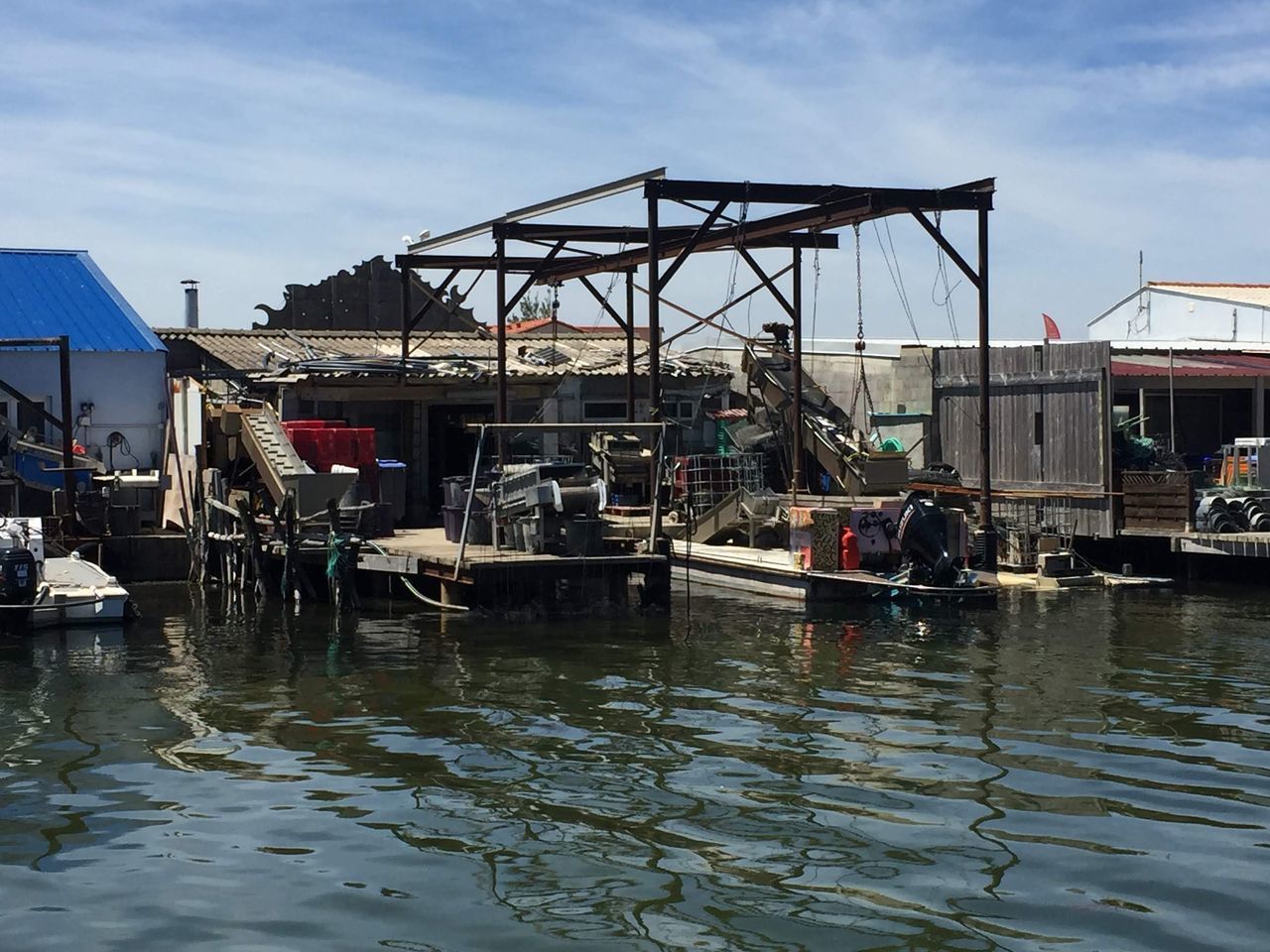 BOATS MOORED IN RIVER BY BUILDINGS AGAINST SKY