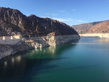 Scenic view of lake and mountains against blue sky