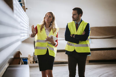 Man and woman in warehouse supervising stock