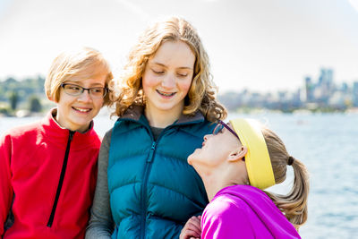 Portrait of smiling happy friends against sky