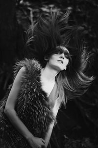 Portrait of young woman with tousled hair wearing fur dress