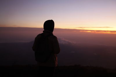 Silhouette man standing against sky during sunset