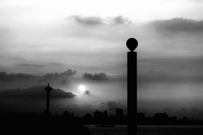 Silhouette street light against sky in city at dusk
