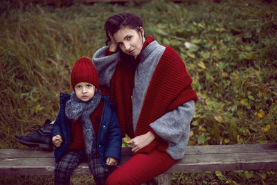 Mom and son sitting on a street bench in the fall