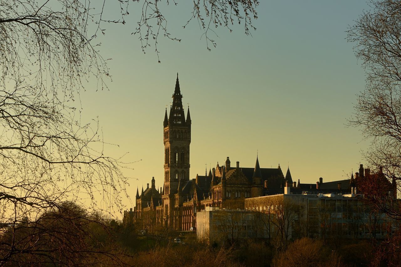 VIEW OF TOWER IN CITY AT SUNSET