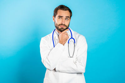 Mid adult man standing against blue background