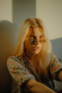 Portrait of a young woman wearing sunglasses during sunset