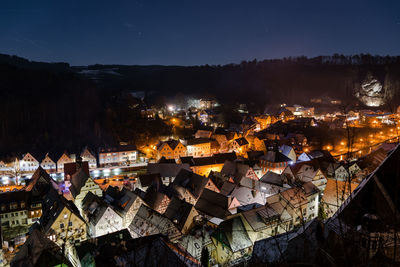 High angle view of illuminated town against sky at night