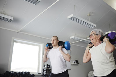 Woman exercising with dumbbell with weights in gym