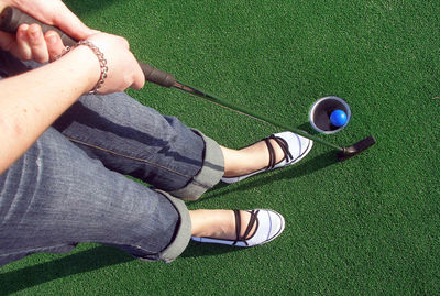 Low section of woman playing miniature golf