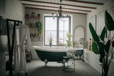 Luxury interior of big bathroom at modern african style with oval bathtub in natural lighting