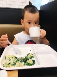 Close-up of boy holding food on table