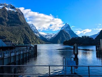 Scenic view of lake and mountains against blue sky