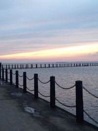 Pier over sea against sky during sunset