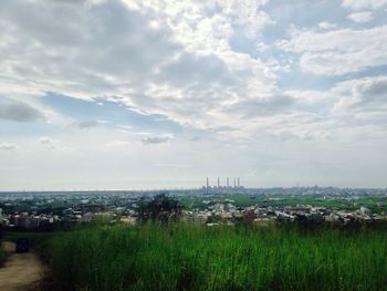 View of cityscape against cloudy sky
