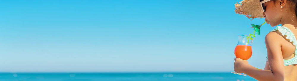 Midsection of woman holding sea against sky