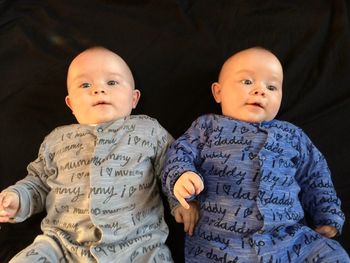 High angle view of twin baby boys lying on bed