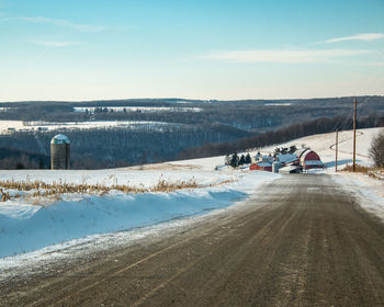 Road by mountain against sky during winter