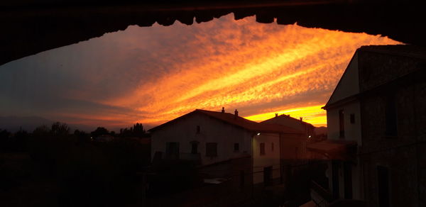 Silhouette buildings against sky during sunset